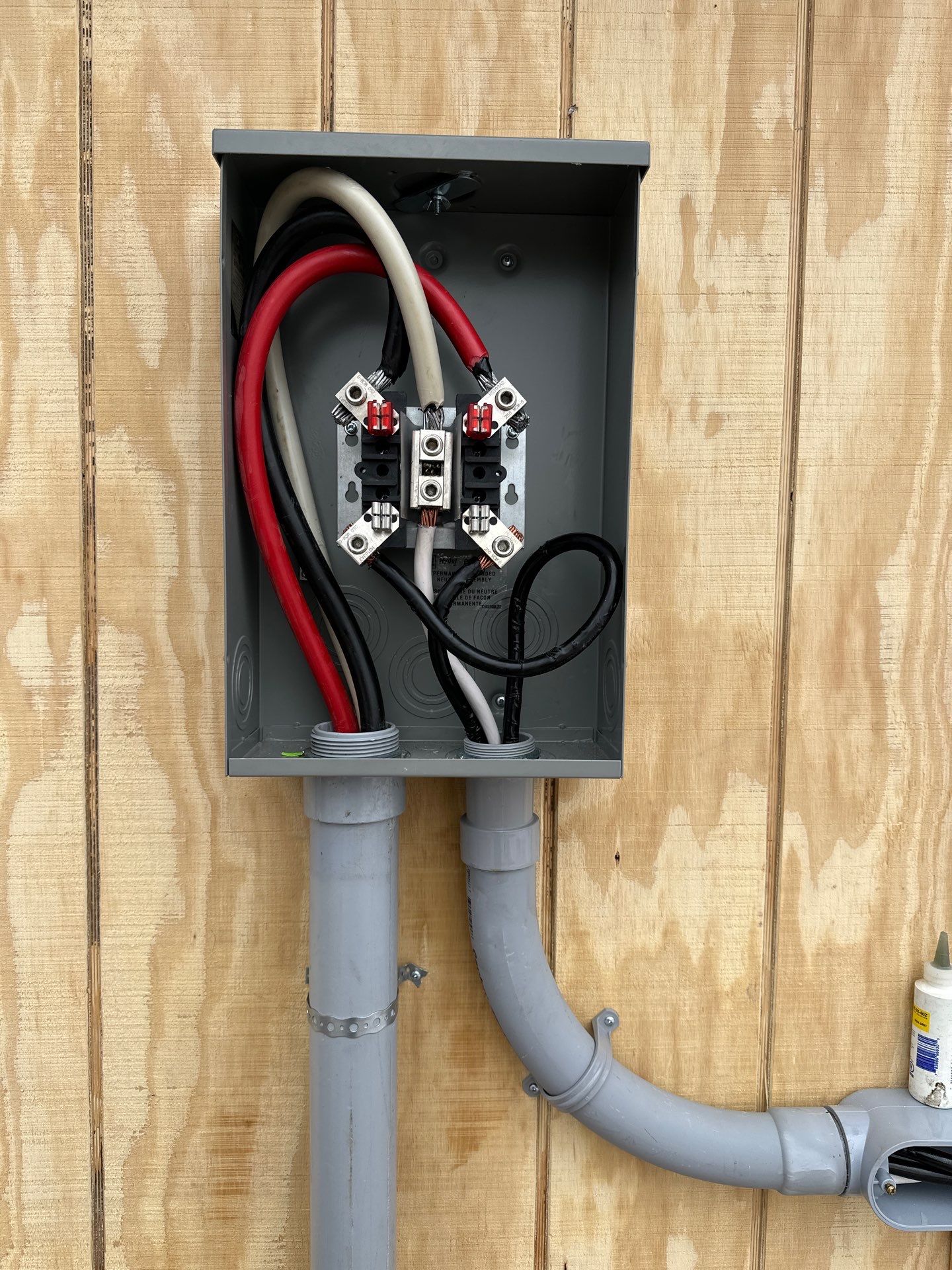 Exterior service equipment with conductors and conduit on unfinished structure wall