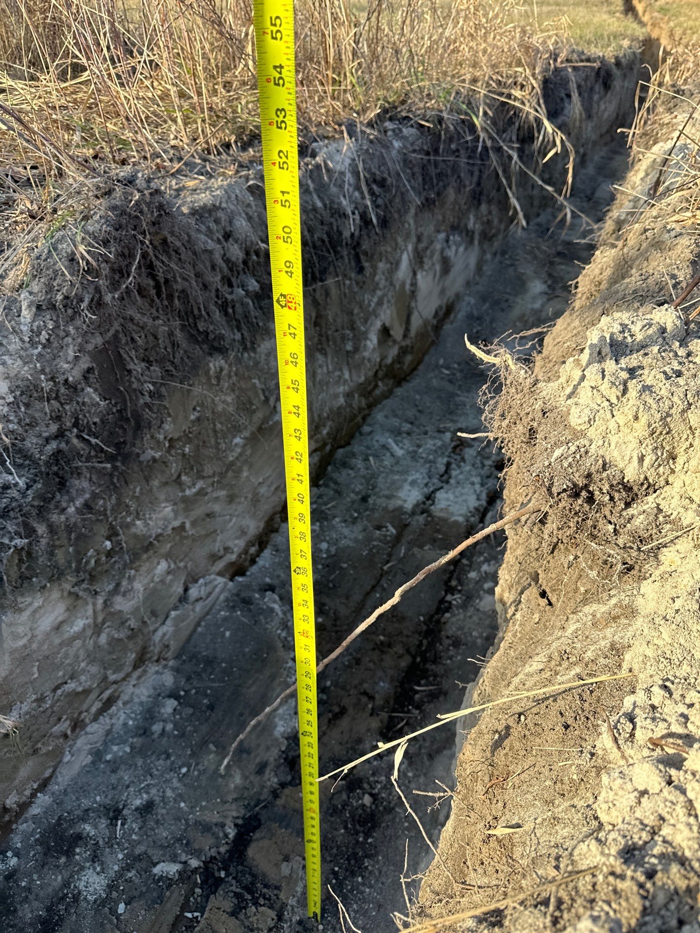 Measuring tape showing trench depth for underground service routing